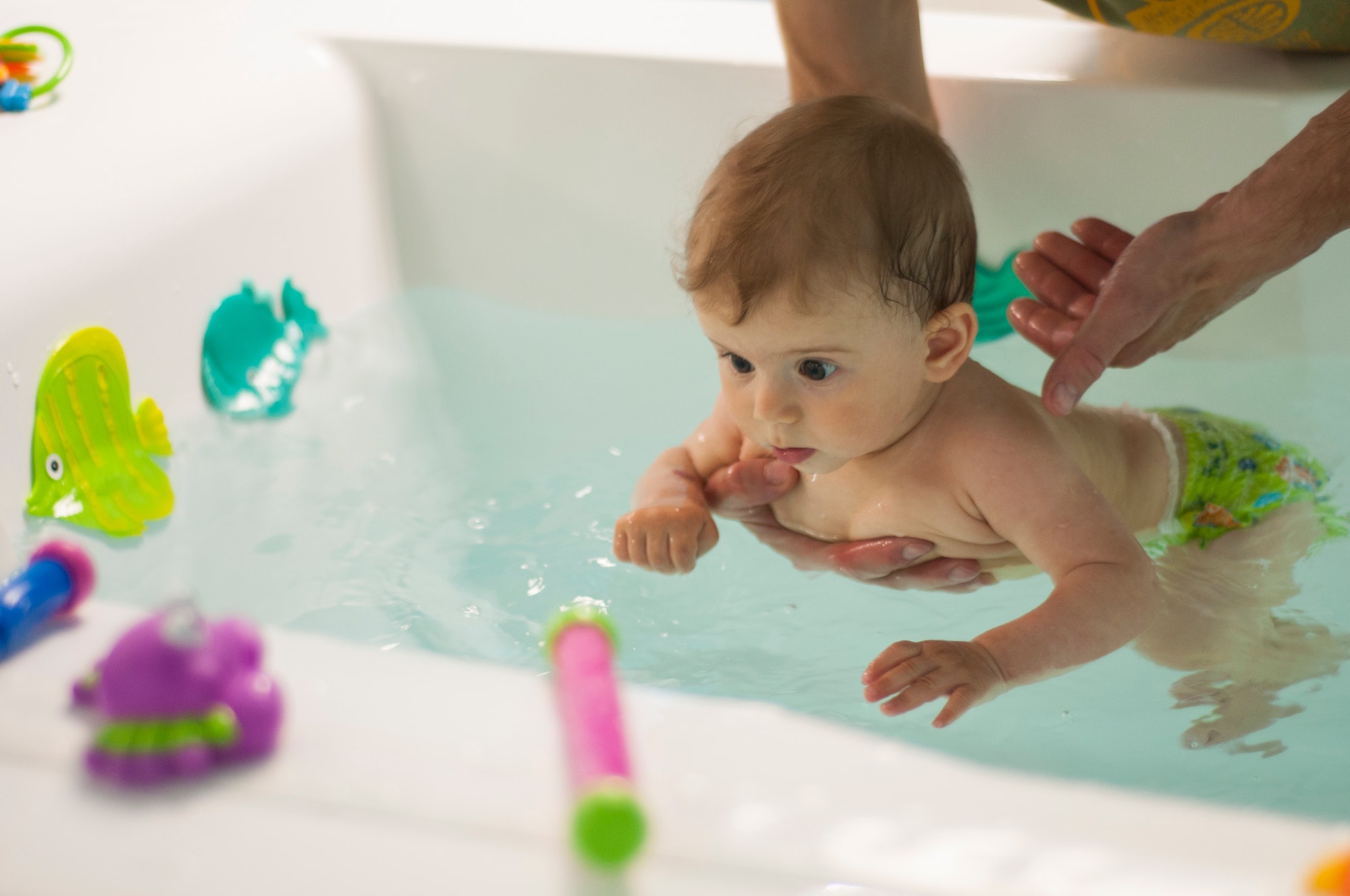 Baby swimming in the bath with toys. Pool for babies. Children’s toys for playing in water. Baby swimming in the bath with toys. Pool for babies. Children's toys for playing in water.