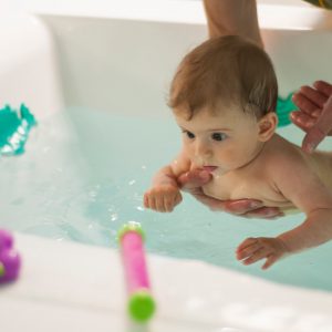 Baby swimming in the bath with toys. Pool for babies. Children’s toys for playing in water. Baby swimming in the bath with toys. Pool for babies. Children's toys for playing in water.