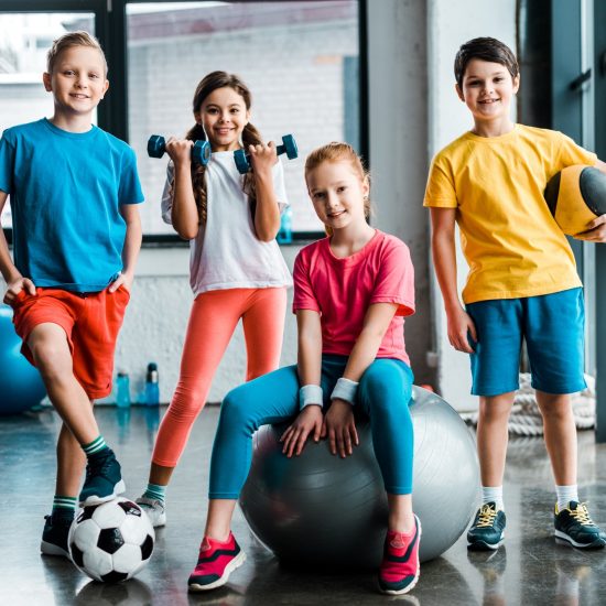 Laughing preteen kids posing with sport equipment Laughing preteen kids posing with sport equipment